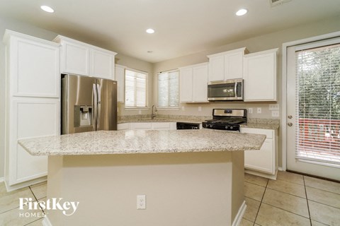 a kitchen with white cabinets and a granite counter top