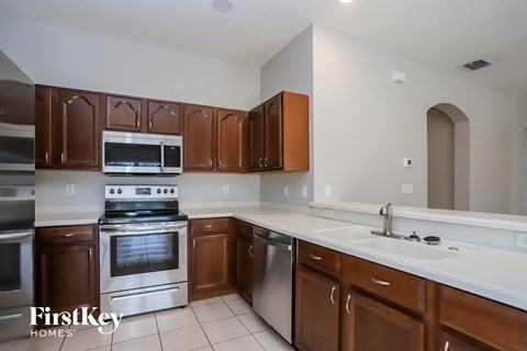 A kitchen with brown cabinets and stainless steel appliances.