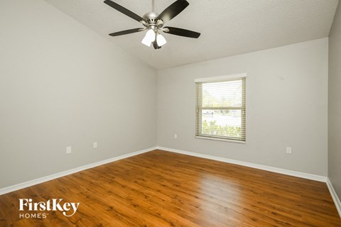 a living room with wood floors and a ceiling fan