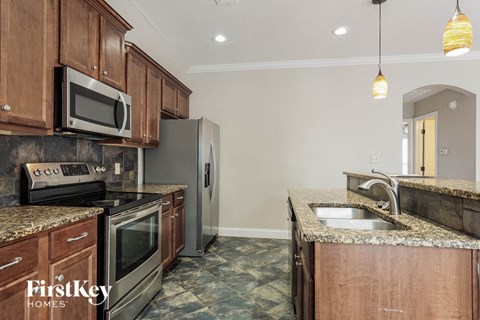 A kitchen with granite countertops and stainless steel appliances.