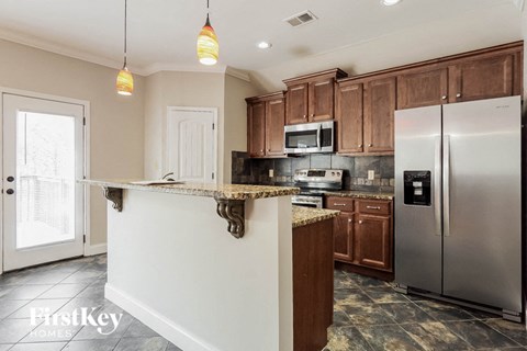 A kitchen with a white counter top and a stainless steel refrigerator.