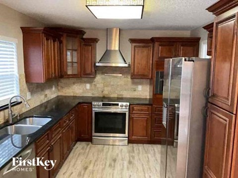 a kitchen with wooden cabinets and stainless steel appliances