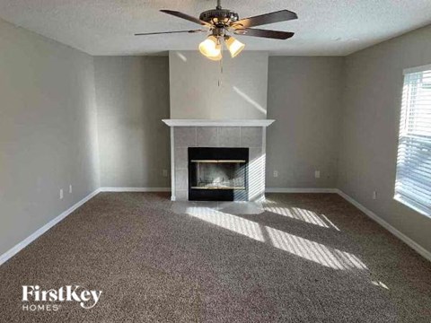 a living room with a fireplace and a ceiling fan