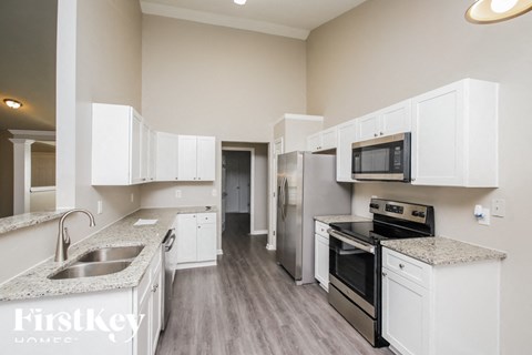 A kitchen with white cabinets and stainless steel appliances.