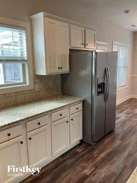 a kitchen with white cabinets and a stainless steel refrigerator