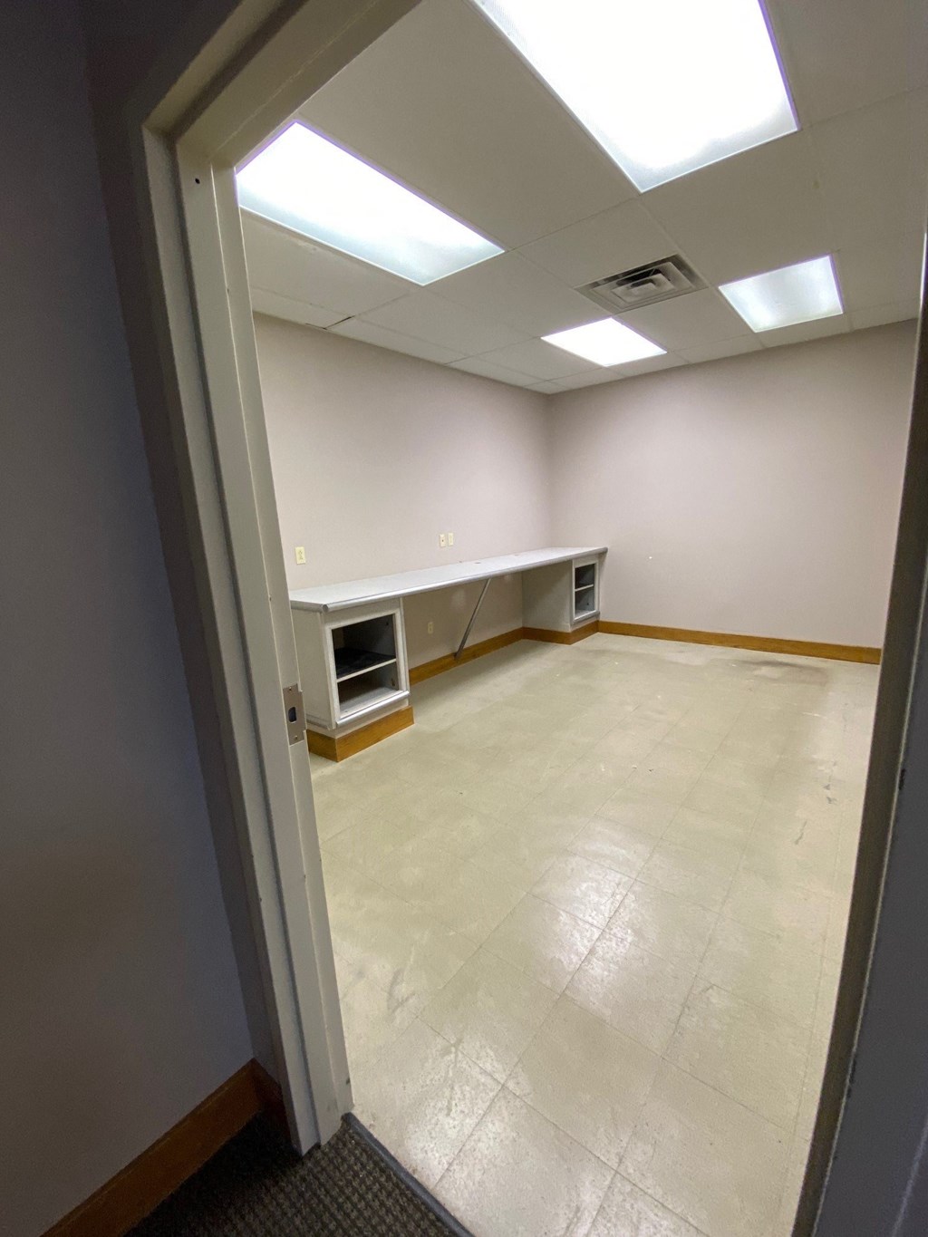 an empty room with a tile floor and white walls