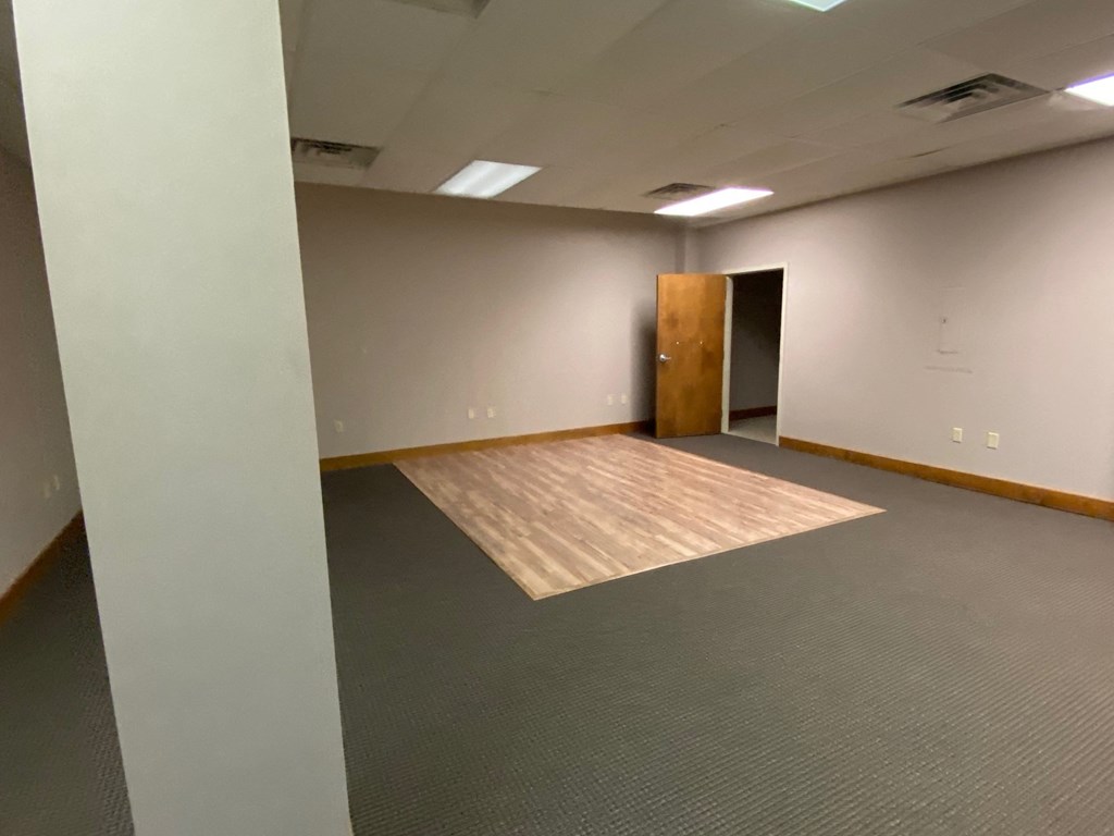 an empty room with a wood floor and a door