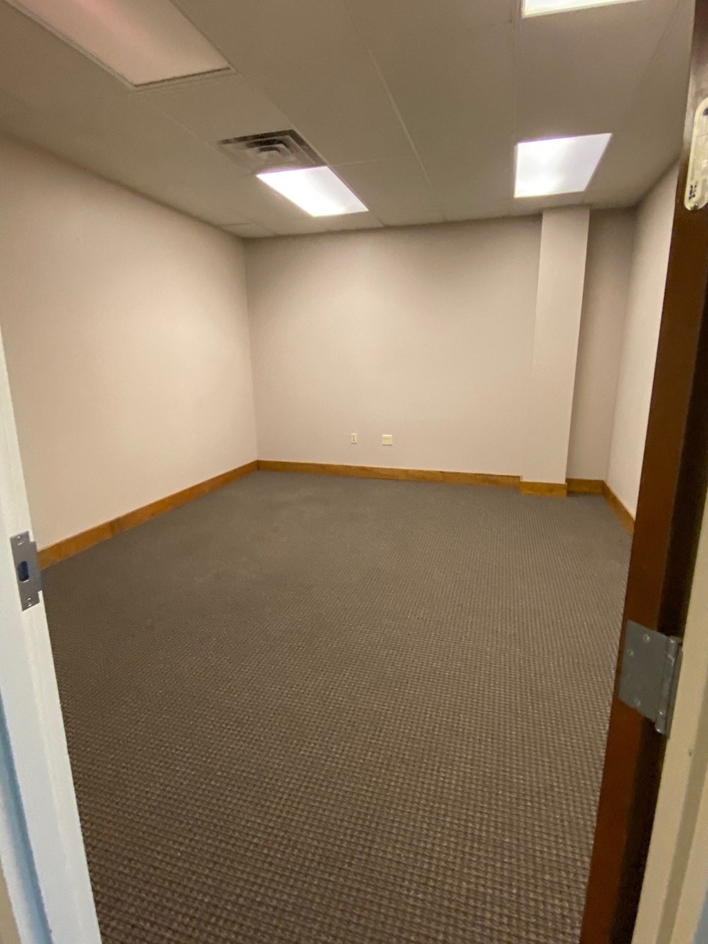 a room with a carpeted floor and a door