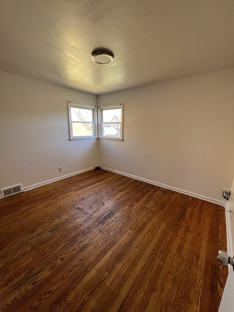 the living room of an empty house with wood floors