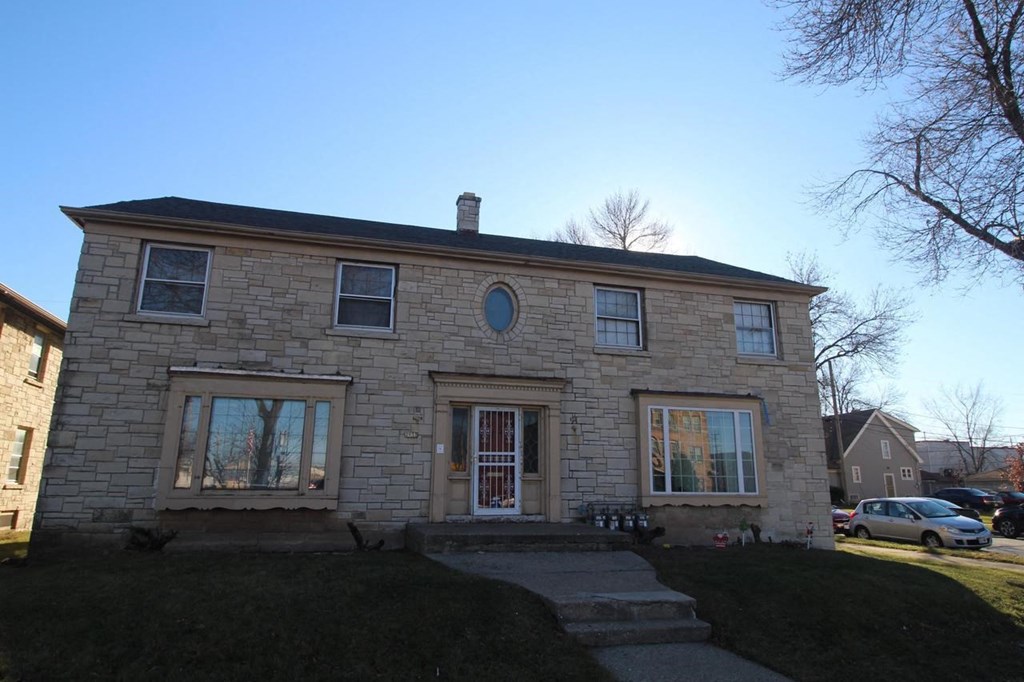 the front of a brick house with a clear blue sky