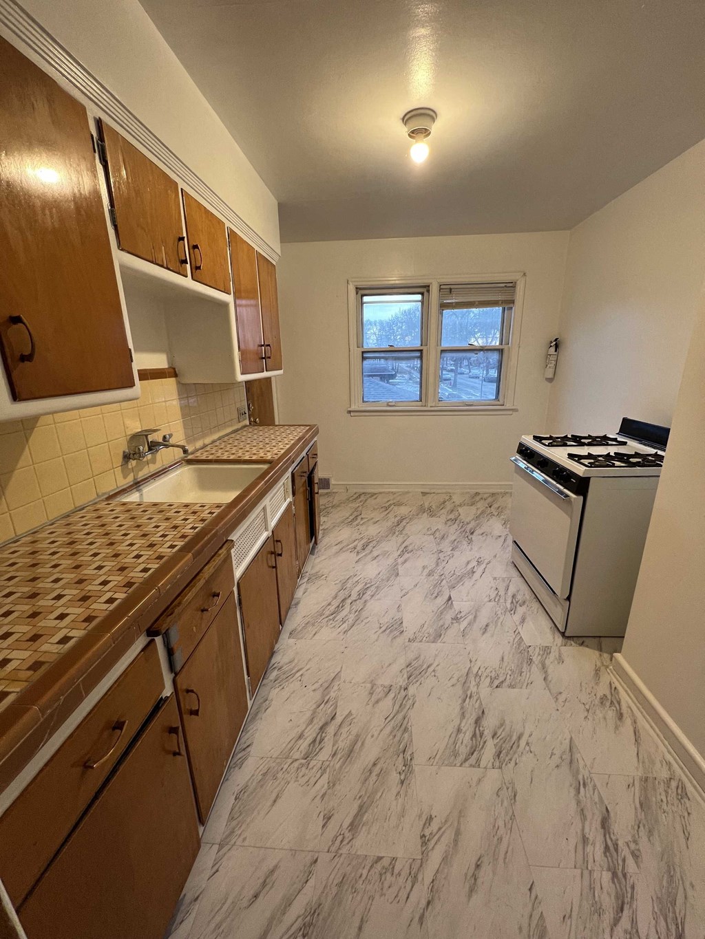 an empty kitchen with a stove and a sink