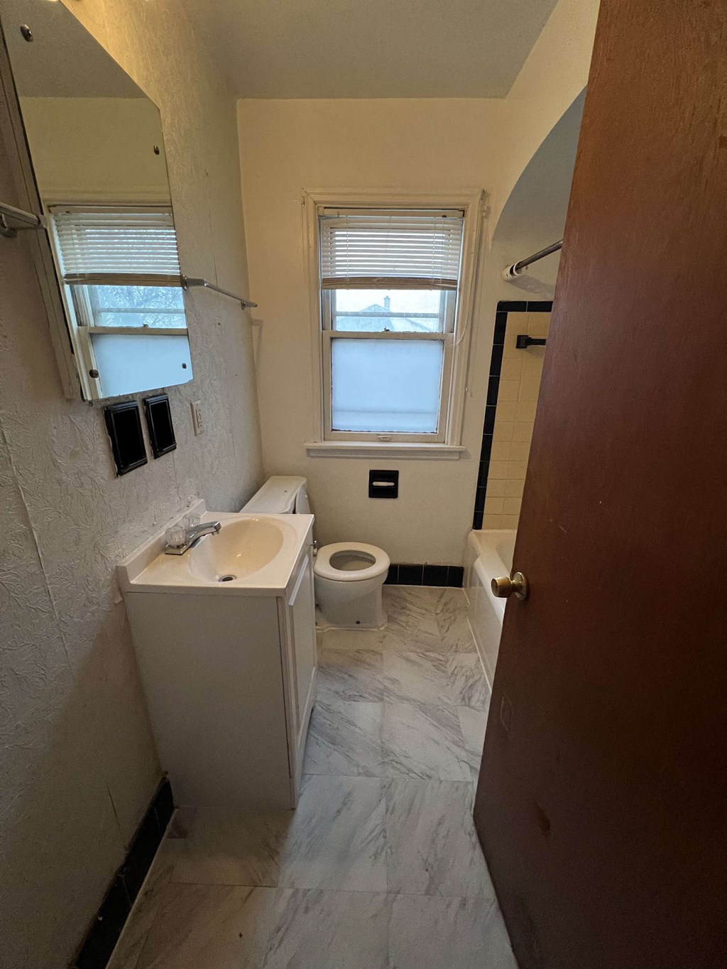 a bathroom with a toilet and a sink and a window