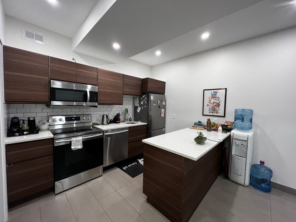 a kitchen with stainless steel appliances and a white counter top
