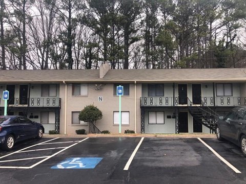 an apartment building with cars parked in a parking lot