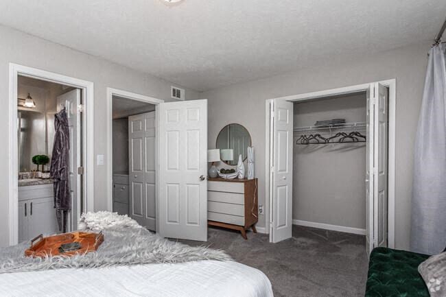 a bedroom with a bed and a closet and a mirror