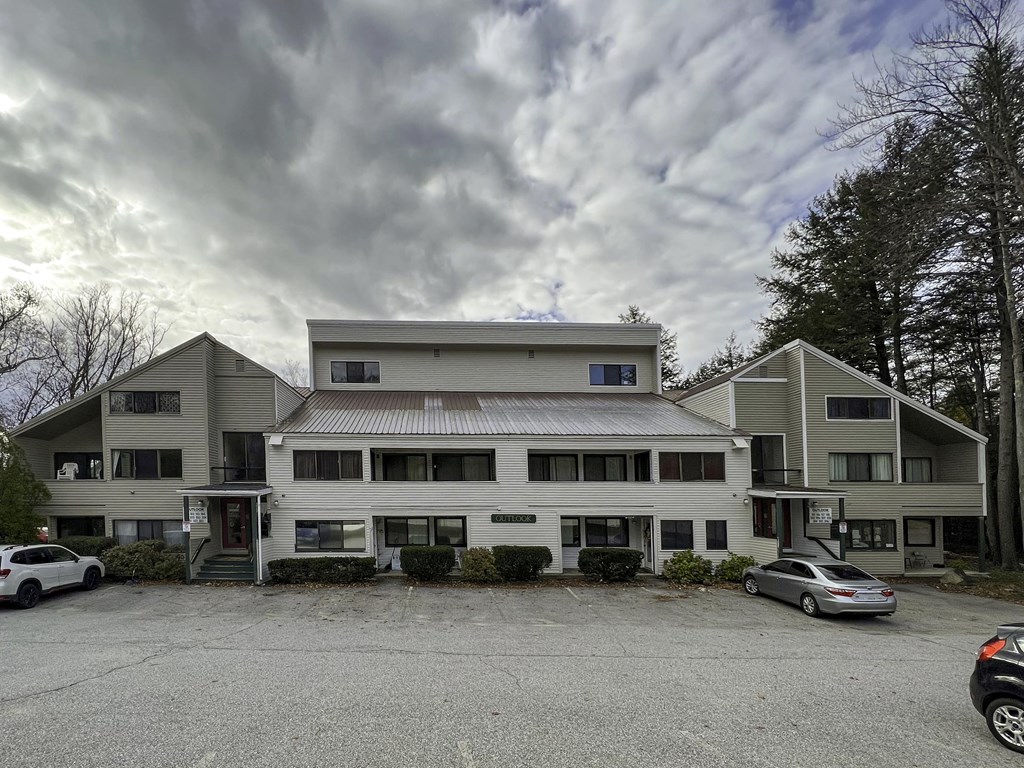 a large white building with cars parked in front of it
