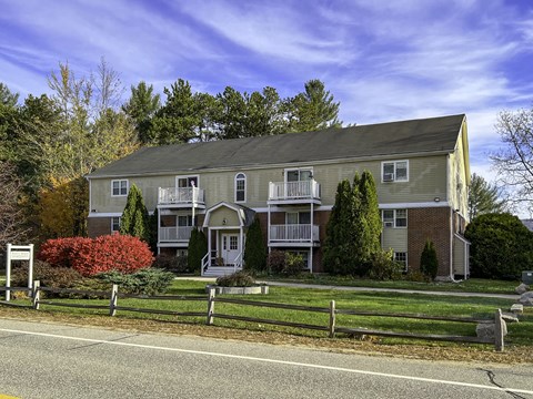 a house on the side of a road with a fence