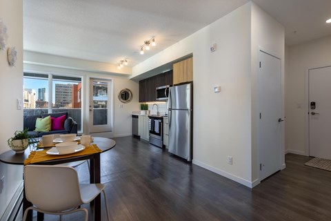 A kitchen with a table and chairs in front of a window.