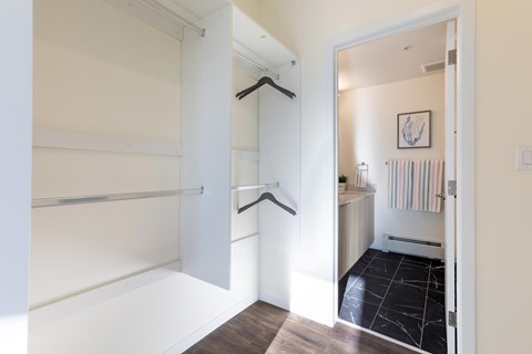 A white hallway with a black and white tiled floor.