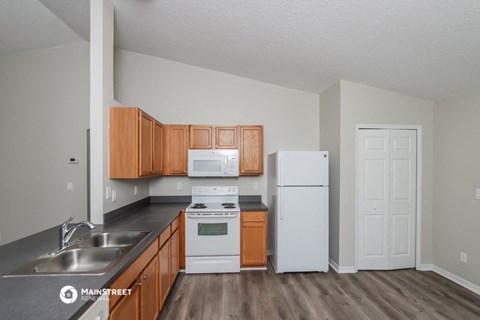 a kitchen with white appliances and wooden cabinets