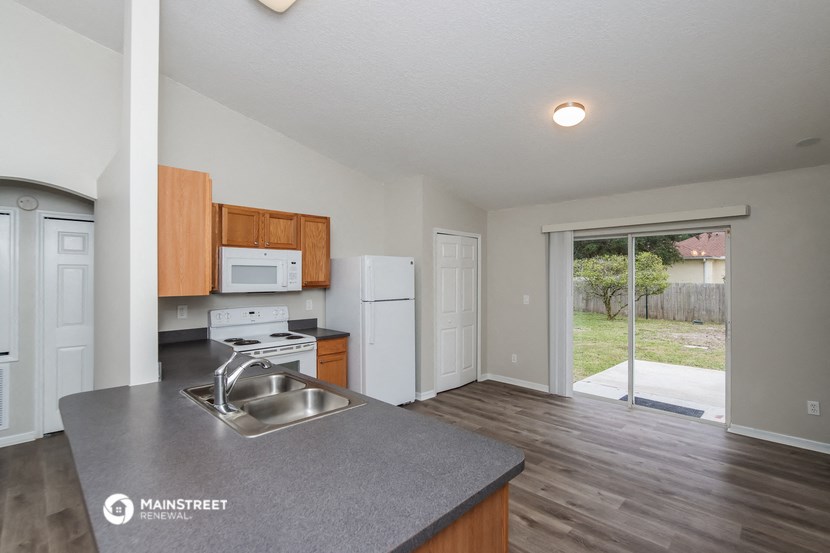 the kitchen of an apartment with a large window and a stainless steel sink