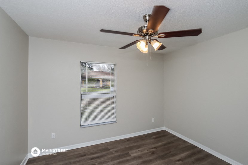 the living room of our studio apartment atrium with ceiling fan and window