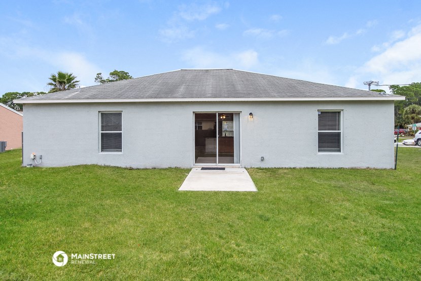 the front of a white house with a green lawn