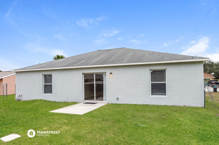 the front of a white house with a grassy yard