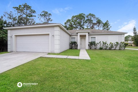 a white house with a lawn and a driveway