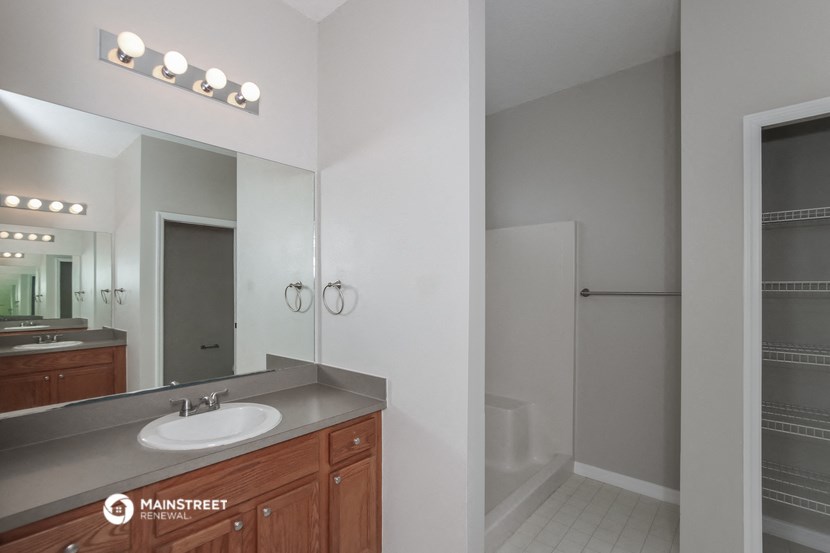 a bathroom with a sink and a mirror and a shower