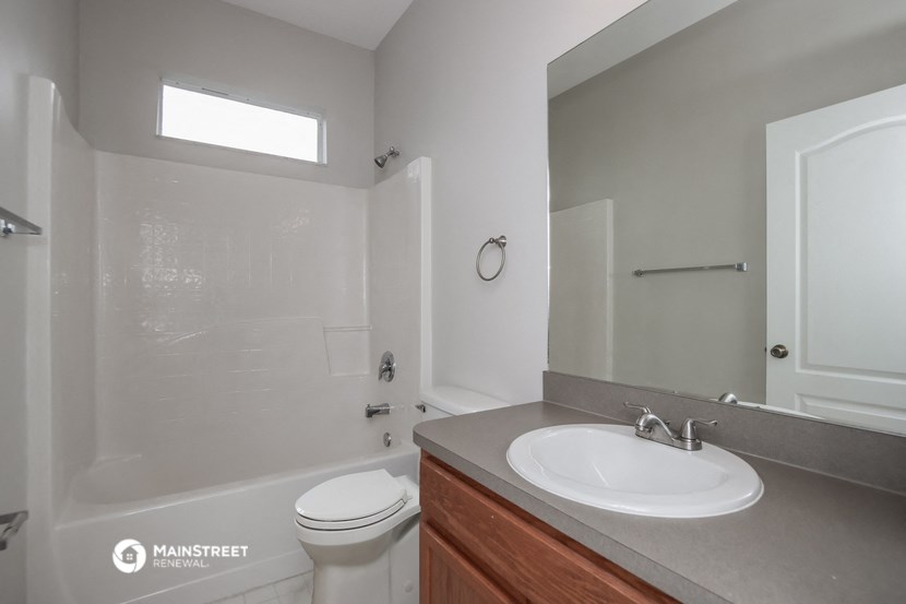 an empty bathroom with a sink toilet and shower