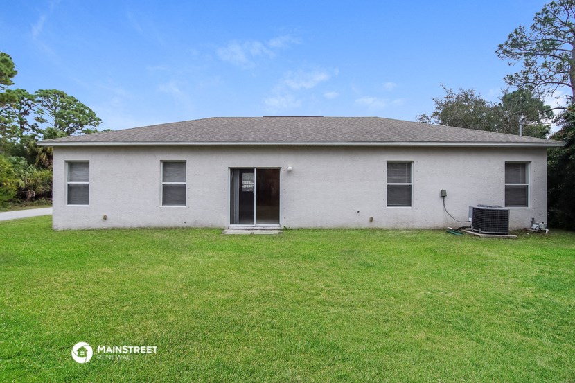 a small white house with a grassy yard in front
