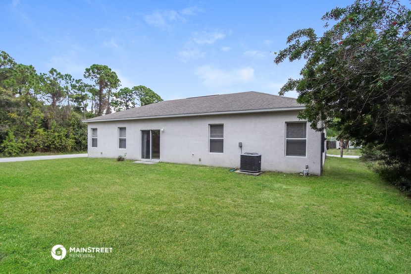 a white house with a grassy yard and trees
