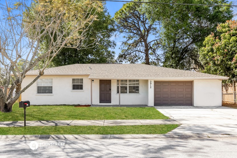 a white house with a lawn and a garage