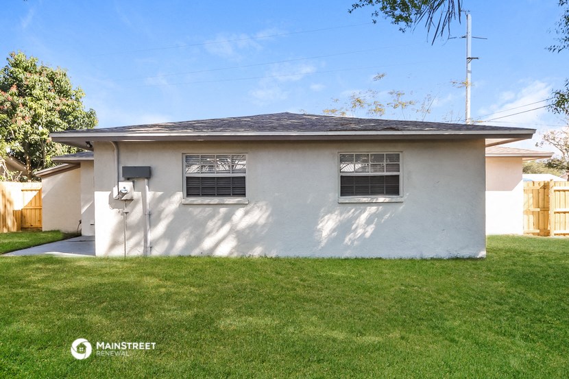 a small white house with two windows and a lawn