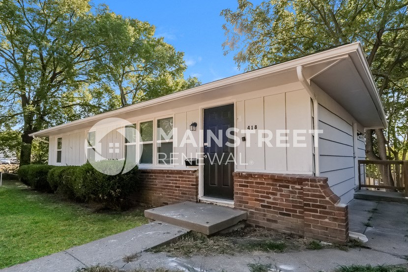 a small house with a brick front porch and a sidewalk