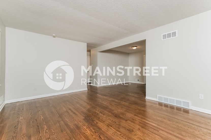 a living area with hardwood floors and white walls and