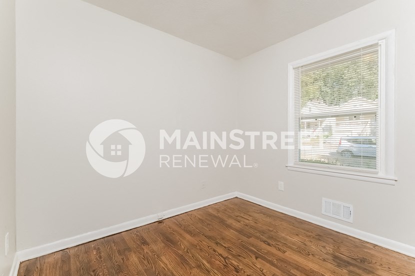 a bedroom with a hard wood floor and a window