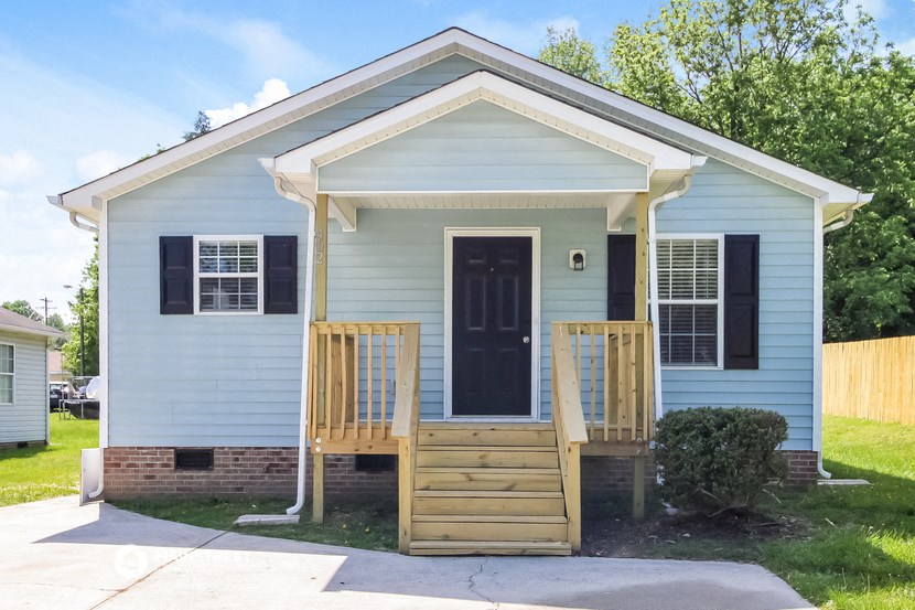 a blue house with a front porch and a black door