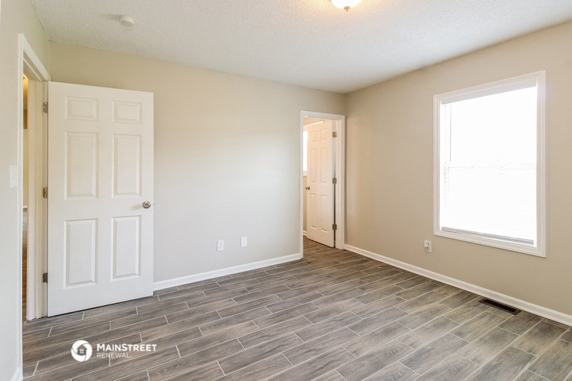 the living room and entrance of a house with a white door