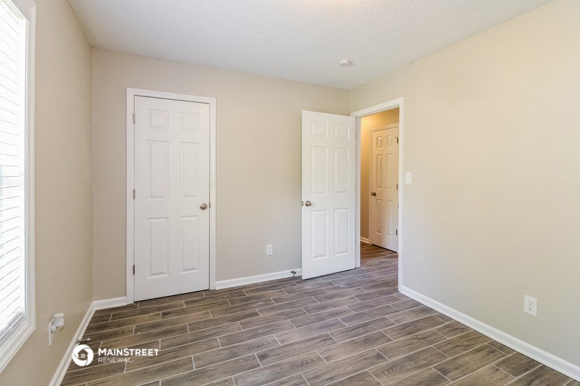 the living room and entrance to the bedroom of a house