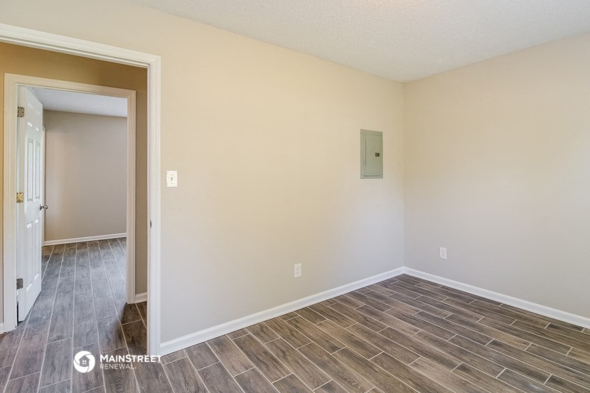 the living room and dining room of a house with wood flooring