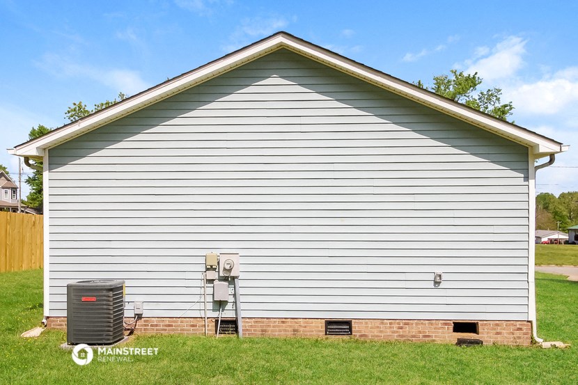 the side of a garage with a heater on the side