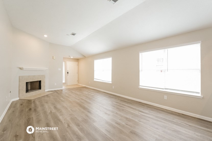 the living room of a new home with wood flooring and a fireplace