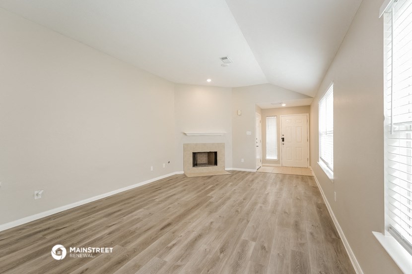 the living room with wood flooring and a fireplace