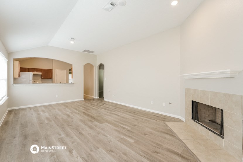 the living room with fireplace and wood flooring