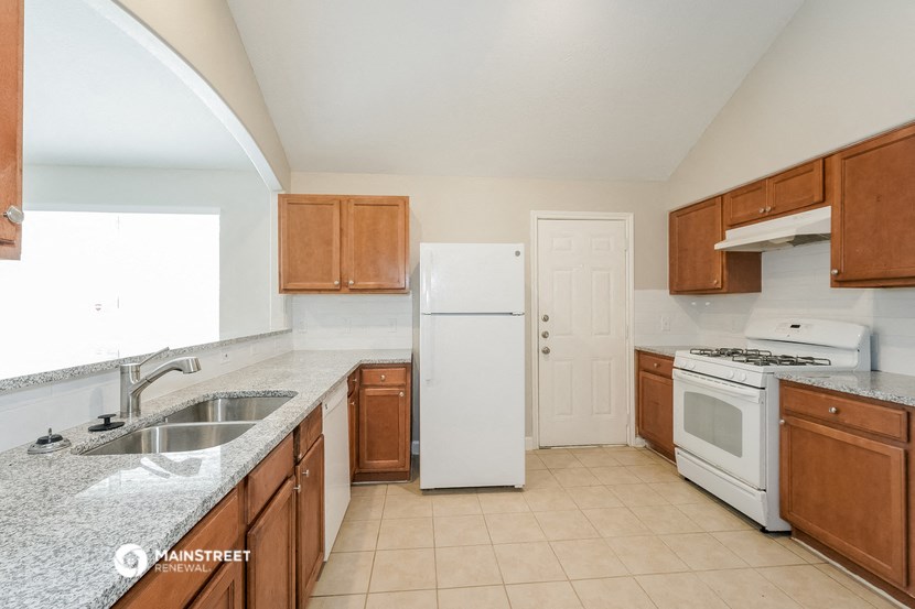 a kitchen with wooden cabinets and white appliances and a sink