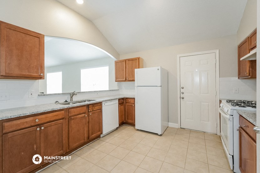 a kitchen with wooden cabinets and a white refrigerator