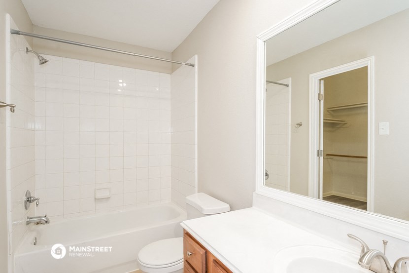 a bathroom with a tub and a sink and a mirror