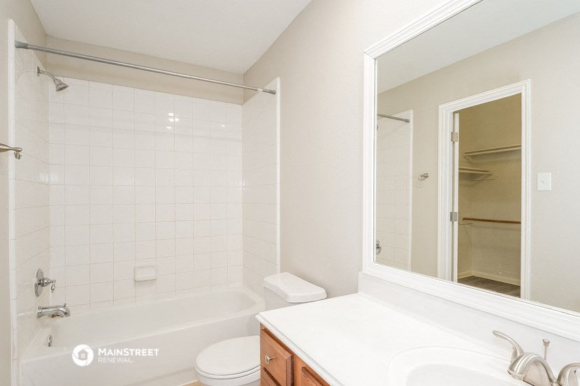a bathroom with a tub and a sink and a mirror